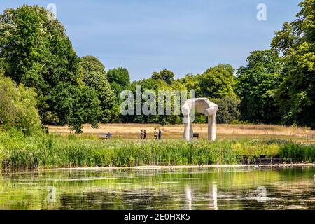 People Walking und "The Arch" Skulptur von Henry Moore im Hyde Park, London, Großbritannien Stockfoto