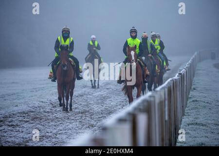 Bild vom 31. Dezember zeigt Jockeys auf den Rennpferden, die auf Newmarket Galopps in Suffolk trainieren, bei einem eisigen und nebligen Start in die Silvesternacht.Schnee wird für einige Teile Großbritanniens in den nächsten Tagen prognostiziert. Stockfoto