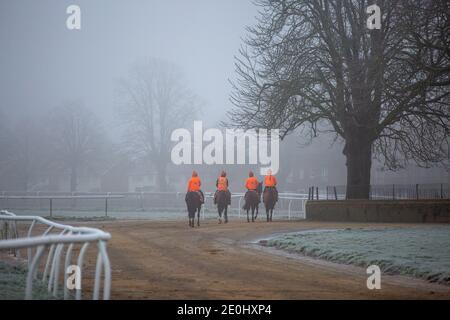 Bild vom 31. Dezember zeigt Jockeys auf den Rennpferden, die auf Newmarket Galopps in Suffolk trainieren, bei einem eisigen und nebligen Start in die Silvesternacht.Schnee wird für einige Teile Großbritanniens in den nächsten Tagen prognostiziert. Stockfoto