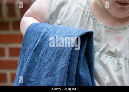 Nahaufnahme einer Frau Falten faltig blaue Jeans draußen Stockfoto
