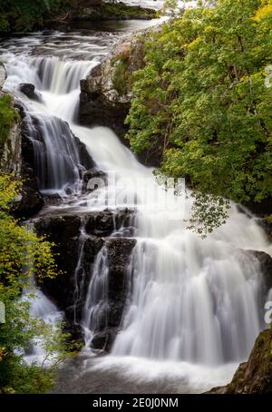 Herbstansicht der nebligen Linn Falls am berühmten Angus Glens of Glen Isla. Reekie Linn ist einer der spektakulärsten Wasserfälle Schottlands, der durch einen tiefen, von Bäumen gesäumten Canyon mit einer wunderschönen herbstlichen und farbenfrohen Landschaft westlich des Angus County in Schottland, Großbritannien, stürzt Stockfoto