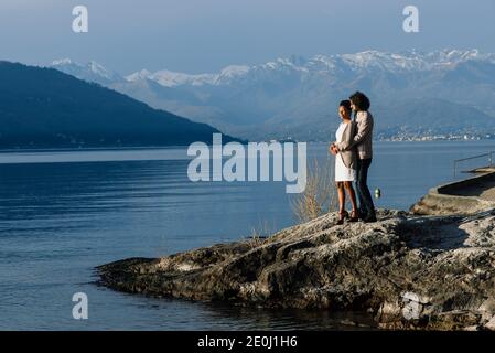 Junge Erwachsene interracial Paar an einem Strand, kaukasischen Mann und afroamerikanische Frau in Freizeitkleidung an einer Küste, valentinstag Stockfoto