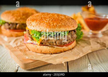 Frischer amerikanischer Hamburger mit Rind- und Tomatensauce auf Holz Platine Stockfoto