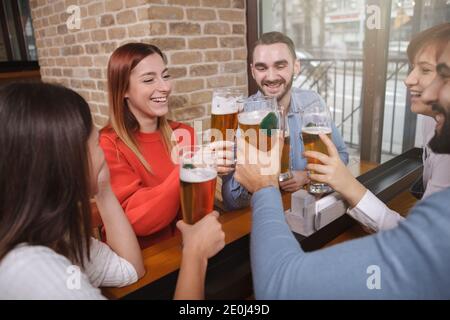 Eine Gruppe junger Leute, die gemeinsam im Pub Bier trinken. Freundschaft, Wochenende, Relax-Konzept Stockfoto