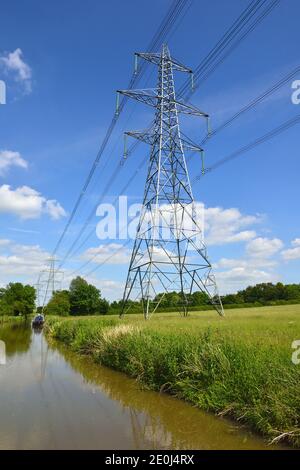 Strommasten, die Oberleitungen über Felder transportieren, Ashby Canal, Swadlincote, Midlands, Vereinigtes Königreich Stockfoto