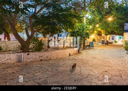 Folegandros Island, Chora, Griechenland - 23. September 2020: Blick auf den Hauptplatz von Chora mit lokalen Restaurants am Abend. Außentische mit gue Stockfoto