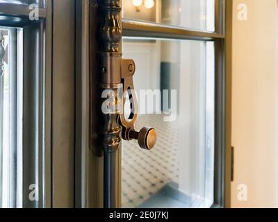 Brauner Fensterrahmen und moderner Fenstergriff. Unscharfer Hintergrund. Stockfoto