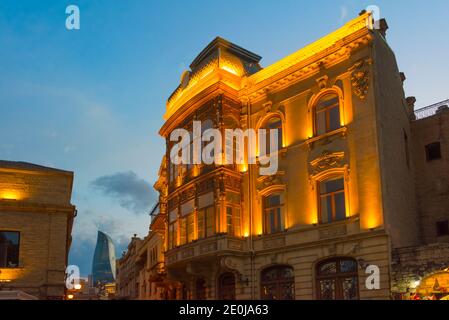 Nachtansicht der traditionellen Gebäude in der Altstadt, Flame Towers in der Ferne, Baku, Aserbaidschan Stockfoto