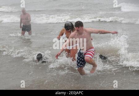 Racine, Wisconsin, USA. Januar 2021. Obwohl die jährliche Wohltätigkeitsorganisation Splash and Dance Eisbären stürzen in North Beach am Lake Michigan in Racine, Wisconsin wegen der Pandemie abgesagt wurde, etwa drei Dutzend Menschen stürzten in das 40-Grad-Wasser sowieso Freitag, 1. Januar 2021. Schnee und Schlitten aus dem Osten - dem See - zu fahren begann die Schwimmer zu beworfen, als sie sich bereit machten. (Bild: © Mark HertzbergZUMA Wire) Quelle: ZUMA Press, Inc./Alamy Live News Stockfoto