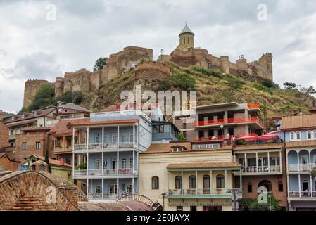 Häuser in Abanotubani Bezirk, Narikala Festung und St. Nicholas Kirche auf hohen Klippen, Tiflis, Georgien Stockfoto