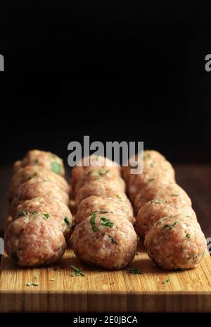 Frische rohe Fleischbällchen isoliert auf Holztisch. Speicherplatz kopieren. Stockfoto