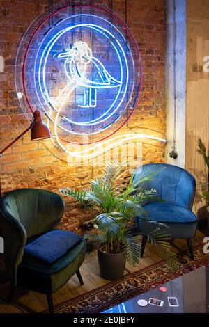 15. Dezember 2020, St. Petersburg Russland. Möwenvogel aus Neon buntes Licht an Backsteinmauer im Café. Stockfoto
