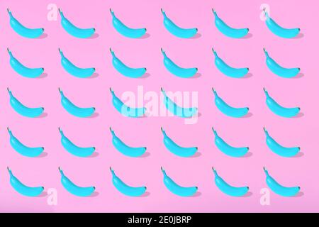 Trendige Sommer-Muster mit frischen Bananenfrucht in blau auf hellrosa Hintergrund. Minimales Sommerkonzept. Stockfoto