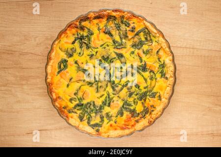 Lachs Fisch und Spinat Quiche Pie - hausgemachte Rezept Pie in der Mitte des Holztisches Hintergrund mit Kopierraum, Draufsicht. Selektiver Fokus Stockfoto