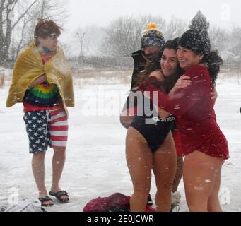 Racine, Wisconsin, USA. Januar 2021. Obwohl die jährliche Wohltätigkeitsorganisation Splash and Dance Eisbären stürzen am North Beach am Lake Michigan wegen der Pandemie abgesagt wurde, stürzten sich immerhin etwa drei Dutzend Menschen in das 40-Grad-Wasser. Schnee und Schlitten aus dem Osten - dem See - zu fahren begann die Schwimmer zu beworfen, als sie sich bereit machten. (Bild: © Mark HertzbergZUMA Wire) Quelle: ZUMA Press, Inc./Alamy Live News Stockfoto