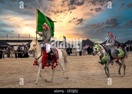 Saudi Arab Horse Rider mit Saudi-Arabien Nationalflagge auf traditionellen Wüstensafari Festival in abqaiq Saudi-Arabien. 10-Jan-2020 Stockfoto