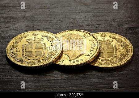 Italienische 20 Lira Goldmünzen auf rustikalem Holzhintergrund Stockfoto