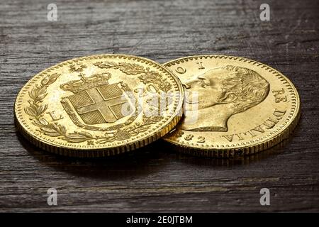 Italienische 20 Lira Goldmünzen auf rustikalem Holzhintergrund Stockfoto