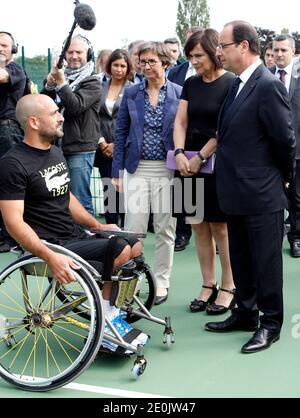 Der französische Präsident Francois Hollande flankierte die französische Sportministerin Valerie Fourneyron und die französische Juniorministerin für behinderte Menschen Marie-Arlette Carlotti trifft den französischen Rollstuhltennisspieler und Paralympischen Olympiasieger Michael Jeremiasz, während er das Trainingszentrum des INSEP (Nationales Institut für Sport und Körpererziehung) in Paris besucht. Frankreich am 16. Juli 2012. Foto von Thierry Chesnot/Pool/ABACAPRESS.COM Stockfoto