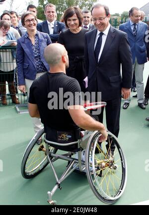 Der französische Präsident Francois Hollande flankierte die französische Sportministerin Valerie Fourneyron und die französische Juniorministerin für behinderte Menschen Marie-Arlette Carlotti trifft den französischen Rollstuhltennisspieler und Paralympischen Olympiasieger Michael Jeremiasz, während er das Trainingszentrum des INSEP (Nationales Institut für Sport und Körpererziehung) in Paris besucht. Frankreich am 16. Juli 2012. Foto von Thierry Chesnot/Pool/ABACAPRESS.COM Stockfoto