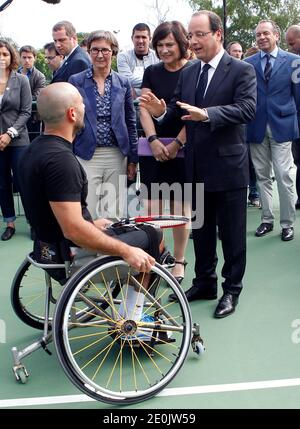 Der französische Präsident Francois Hollande flankierte die französische Sportministerin Valerie Fourneyron und die französische Juniorministerin für behinderte Menschen Marie-Arlette Carlotti trifft den französischen Rollstuhltennisspieler und Paralympischen Olympiasieger Michael Jeremiasz, während er das Trainingszentrum des INSEP (Nationales Institut für Sport und Körpererziehung) in Paris besucht. Frankreich am 16. Juli 2012. Foto von Thierry Chesnot/Pool/ABACAPRESS.COM Stockfoto