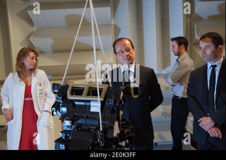 Frankreichs Präsident Francois Hollande (C), flankiert von Frankreichs Juniorminister für soziale und solidarische Wirtschaft Benoit Hamon (R), hört zu, als er am 27. Juli 2012 in La Verriere, außerhalb von Paris, ein Werk des französischen Autoteilelieferanten Valeo besucht. Foto von Bertrand Langlois/POOL/ABACAPRESS.COM Stockfoto