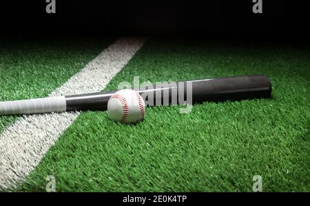 Baseball und graue Fledermaus auf dem Feld mit Streifen und dunkel Hintergrund Stockfoto