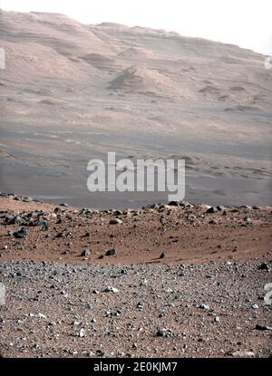 Dieses Bild stammt aus einer Testserie, mit der die 100-Millimeter-Mastkamera auf dem Curiosity Rover der NASA charakterisiert wurde. Es wurde am 23. August 2012 aufgenommen und sieht von der Landeplatz des Rover südwestlich aus. Die 100-Millimeter-Mastcam hat eine dreimal bessere Auflösung als die 34-Millimeter-Mastcam von Curiosity, obwohl sie ein schmaleres Sichtfeld hat. Im Vordergrund ist die kiesige Gegend um die Landestelle von Curiosity zu sehen. Weiter entfernt, etwa ein Drittel des Weges vom unteren Bildrende nach oben, fällt das Gelände in eine Senke (eine Mulde). Hinter der Mulde, in der Mitte des Bildes, ist der bou Stockfoto