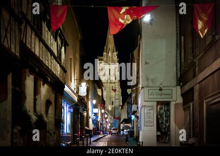 Nachtansicht der mittelalterlichen Altstadt von Bayeux, Frankreich, mit der Bayeux Kathedrale im Blick und die Flagge von Calvados hing auf der anderen Straßenseite. Stockfoto