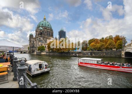 Touristen genießen einen Herbstnachmittag in einem Café am Wasser und fahren entlang der Spree mit Blick auf den Berliner Dom. Stockfoto