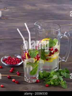 Hausgemachte Preiselbeerlimonade mit Minze auf einem Holztisch, rustikaler Stil Stockfoto