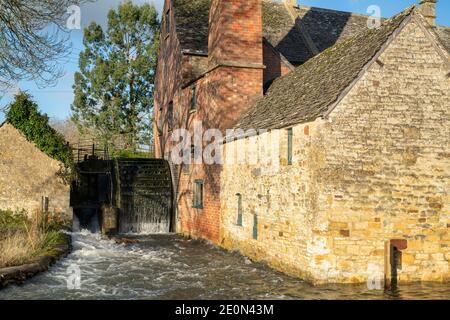 Flussauge hohen Wasserständen rund um die alte Mühle in Lower Slaughter am Heiligabend. Lower Slaughter, Cotswolds, Gloucestershire, England Stockfoto