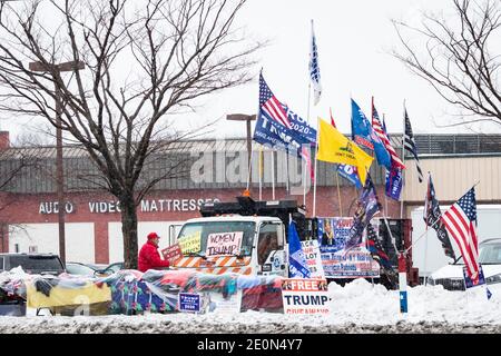 Lange nachdem Donald Trump die Wahl von 2020 verloren hatte, schmückt ein Mann seinen Lastwagen mit einem "Women for Trump"-Zeichen und anderen verschiedenen Pro-Trump-Flaggen und Transparenten Stockfoto