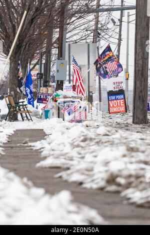 Verschiedene pro-Trump und Anti-Biden-Zeichen und Flaggen, die von Trump-Anhängern im Schnee einige Wochen nach Trump Verlust in der Wahl 2020 Stockfoto