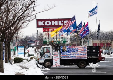 Lange nachdem Donald Trump die Wahl 2020 verloren hatte, schmückt ein Unterstützer seinen Lastwagen mit Pro-Trump- und Anti-Biden-Fahnen und sitzt am Straßenrand im Schnee Stockfoto