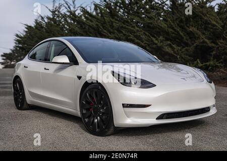 Moss Beach USA - 1. Januar 2021: Pearl White Electric Tesla Model 3 Dual Motor Performance AWD Auto mit 20 Zoll Uberturbine Räder in der Nähe von San Francisco Stockfoto