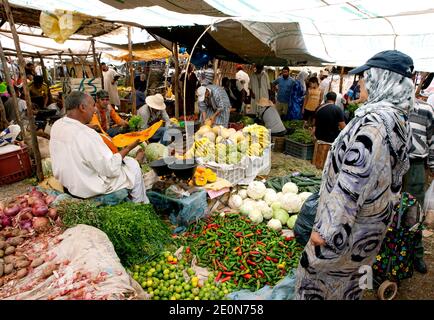 Gemüsehändler mit einem bunten Arrangement von Obst und Gemüse zum Verkauf auf dem Tahanoute Markt im Hohen Atlas von Marokko. Stockfoto