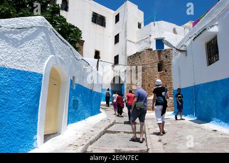 Touristen spazieren durch die schönen Straßen von Kasbah des Oudaias in der Stadt Rabat, Marokko. Dieser Abschnitt von Rabat ist berühmt für seine Architektur. Stockfoto