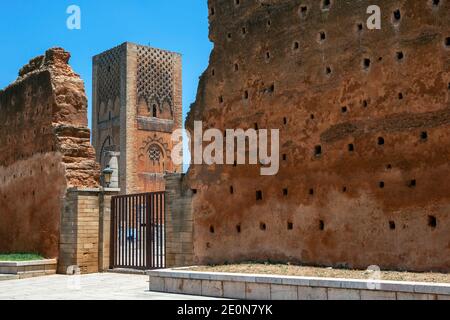 Blick auf den Hassan-Turm durch die Überreste einer Mauer aus dem 12. Jahrhundert in Rabat in Marokko. Der Turm ist das unvollständige Minarett einer Moschee. Stockfoto