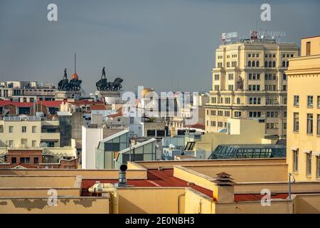 Madrid, Spanien - Panoramablick auf die Dächer der Stadt mit Wagenskulpturen im Hintergrund Stockfoto