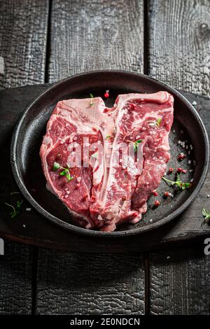 Frisches und rotes Steak mit Salz und Kräutern auf verbrannt Tabelle Stockfoto