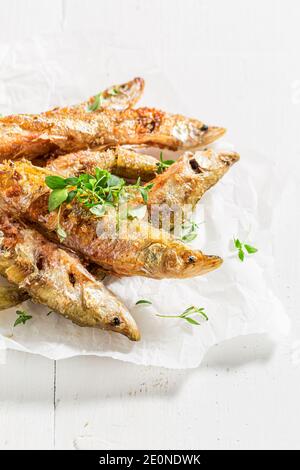 Nahaufnahme von gerochen Fisch und Chips mit Salz und Kräutern Auf Backpapier Stockfoto