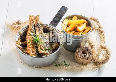 Nahaufnahme von gebratenem roch Fisch und Chips mit Salz auf Weißer Tisch Stockfoto