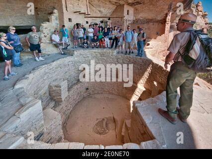 Parkführer und Besucher über Kiva (zeremonielle Kammer) im Balcony House Klippenhaus, Nische in Chaplin Mesa, Mesa Verde National Park, Colorado USA Stockfoto