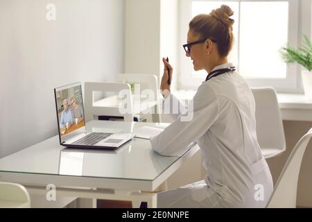 Ein Video der Familienpraktizierenden ruft ein Seniorenpaar an und winkt Hand an Laptop-Computer Stockfoto