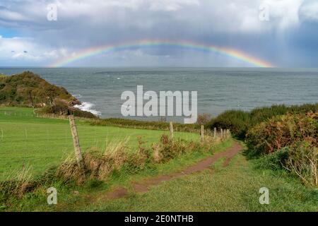 Regenbogen auf See vor der Küste von Devon - England, Großbritannien Stockfoto