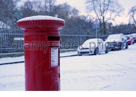 Edinburgh, Schottland, Großbritannien. Januar 2021. Schnee fällt kurz vor Sonnenaufgang im Stadtzentrum. Verschneite Postbox in der Neustadt. Kredit: Craig Brown/Alamy Live Nachrichten Stockfoto