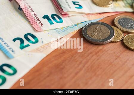 Fan von Euro-Banknoten und einige Münzen auf einem hölzernen Tabelle Stockfoto