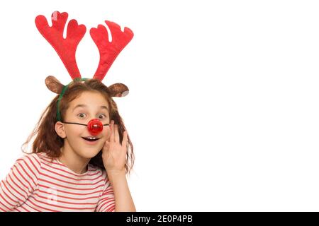 Junge ziemlich lockig behaarte Mädchen trägt rote Nase und Rainhirsch Geweihe lauschen etwas mit der Hand zu ihrem Ohr Isolierter Copyspace, der CH überwacht Stockfoto