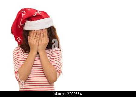 Studioaufnahme eines kleinen Mädchens in Santa Claus Weihnachten hut weinend versteckt ihr Gesicht in ihren Händen isoliert Copyspace Traurige Sadnes deprimierten Angst ängstlich Stockfoto